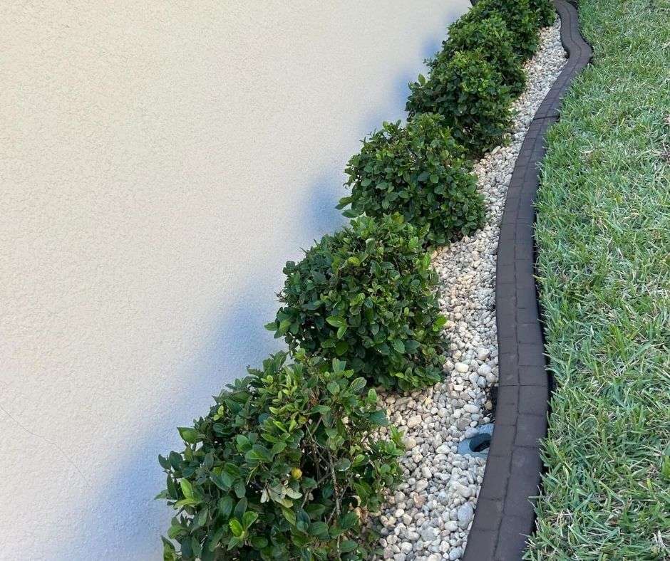 concrete curbing in North Port creating a clean border between landscape rock, manicured shrubs, and a well-kept lawn