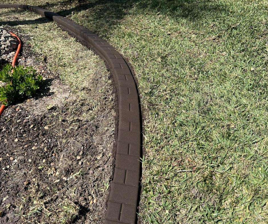 decorative concrete curbing in North Port showing a stamped border design separating lawn and landscape bed