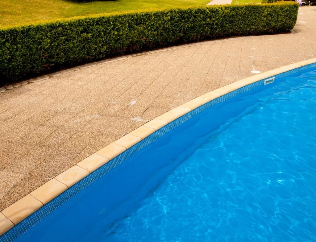 Planning a Paver Pool Deck in Port Charlotte: Heat, Wet Surfaces and Layout 2 Paver pool deck Port Charlotte showing wet textured paving beside a residential swimming pool