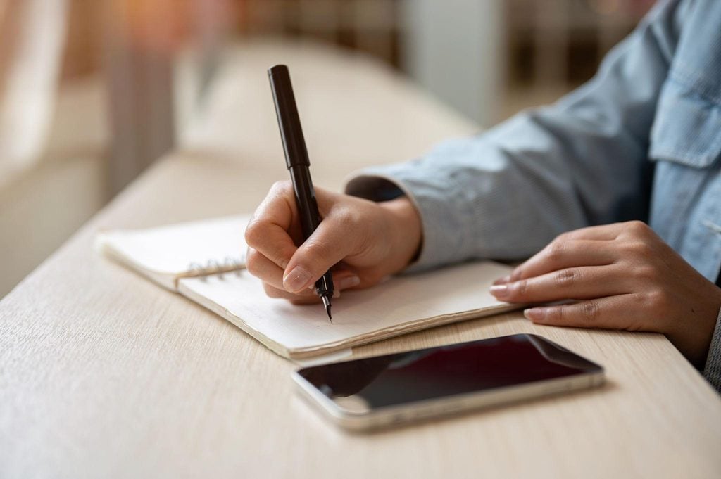 Homeowner writing observations in a notebook between bed bug treatment and follow-up visits